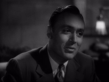 Movie still from “Hold Back the Dawn” (1941), directed by Mitchell Leisen – A man wearing a suit and tie in a black and white photo; Close Up shot, Over the shoulder angle