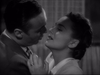 Movie still from “Hold Back the Dawn” (1941), directed by Mitchell Leisen – A man and a woman are kissing in a room; Close Up shot, High angle