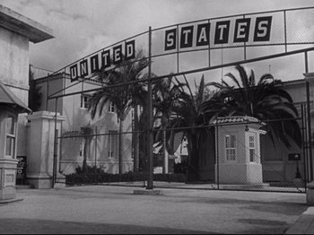 Movie still from “Hold Back the Dawn” (1941), directed by Mitchell Leisen – A black - and - white photo of a united states sign; Extreme Wide shot, Low angle