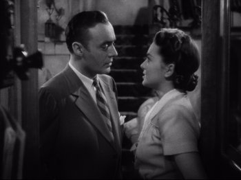 Movie still from “Hold Back the Dawn” (1941), directed by Mitchell Leisen – A man and a woman standing next to each other in front of a staircase; Close Up shot, High angle