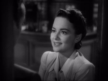 Movie still from “Hold Back the Dawn” (1941), directed by Mitchell Leisen – An old photo of a woman smiling at the camera; Close Up shot, Over the shoulder angle