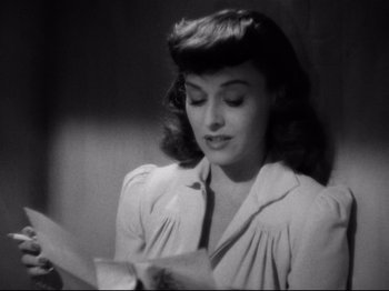 Movie still from “Hold Back the Dawn” (1941), directed by Mitchell Leisen – An old photo of a woman reading a book; Close Up shot, High angle