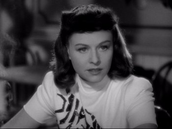 Movie still from “Hold Back the Dawn” (1941), directed by Mitchell Leisen – A black - and - white photo of a woman in a t - shirt; Close Up shot, Over the shoulder angle