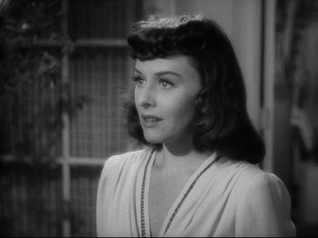 Movie still from “Hold Back the Dawn” (1941), directed by Mitchell Leisen – A black - and - white photo of a woman in a white dress; Close Up shot, Over the shoulder angle