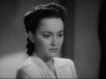 Movie still from “Hold Back the Dawn” (1941), directed by Mitchell Leisen – A black and white photo of a woman in a white shirt; Close Up shot, High angle