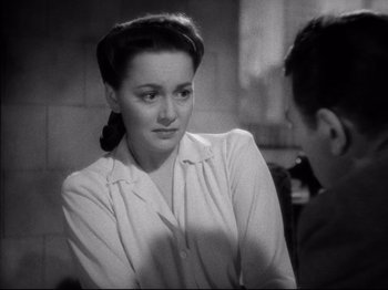 Movie still from “Hold Back the Dawn” (1941), directed by Mitchell Leisen – A woman in a white shirt is talking to a man in a black suit; Close Up shot, Over the shoulder angle