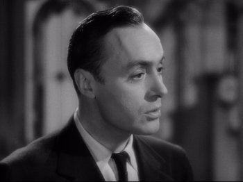 Movie still from “Hold Back the Dawn” (1941), directed by Mitchell Leisen – Black and white photograph of a man in a suit; Close Up shot, Low angle