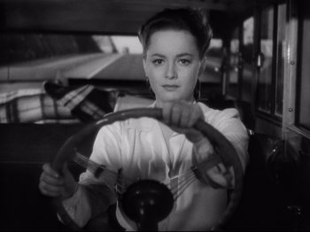 Movie still from “Hold Back the Dawn” (1941), directed by Mitchell Leisen – A woman sitting behind a steering wheel in a car; Close Up shot, High angle