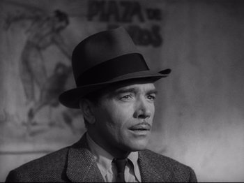 Movie still from “Hold Back the Dawn” (1941), directed by Mitchell Leisen – A man wearing a suit and a hat in a black and white photo; Close Up shot, Low angle