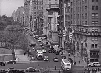 Movie still from “Holiday” (1938), directed by George Cukor – A black and white photo of a city street; Extreme Wide shot, High angle