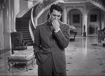 Movie still from “Holiday” (1938), directed by George Cukor – A black and white photo of a man in a suit; Medium shot, High angle