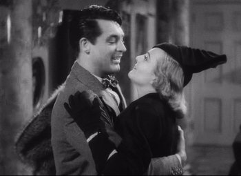 Movie still from “Holiday” (1938), directed by George Cukor – A man and a woman embracing each other in a black and white photo; Medium shot, Low angle