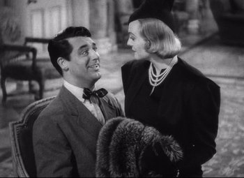 Movie still from “Holiday” (1938), directed by George Cukor – A man and a woman standing next to each other; Medium shot, Over the shoulder angle