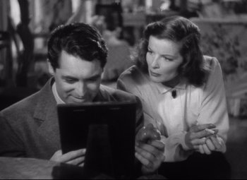 Movie still from “Holiday” (1938), directed by George Cukor – A man and a woman looking at an ipad; Medium shot, Low angle