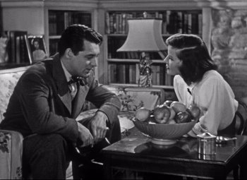 Movie still from “Holiday” (1938), directed by George Cukor – A man and a woman sitting in front of a bowl of fruit; Medium shot, Low angle