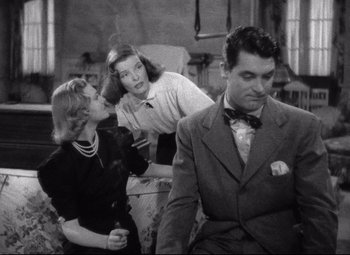 Movie still from “Holiday” (1938), directed by George Cukor – Two women and a man in black and white photo; Medium shot, Over the shoulder angle