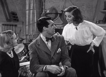 Movie still from “Holiday” (1938), directed by George Cukor – A black and white photo of a man and two women; Medium shot, Over the shoulder angle