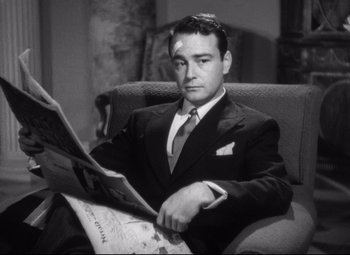 Movie still from “Holiday” (1938), directed by George Cukor – A black and white photo of a man reading a newspaper; Close Up shot, Low angle