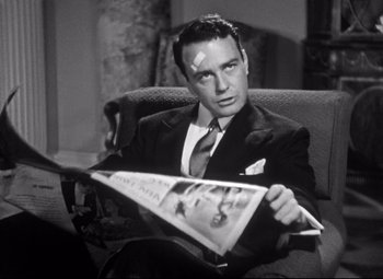 Movie still from “Holiday” (1938), directed by George Cukor – A black and white photo of a man reading a newspaper; Close Up shot, Low angle