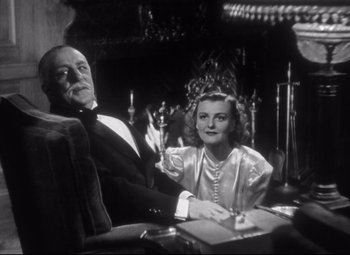 Movie still from “Holiday” (1938), directed by George Cukor – An old photo of a man and a woman sitting at a table; Medium shot, Low angle
