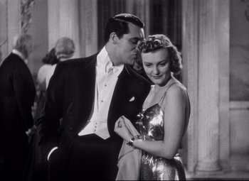 Movie still from “Holiday” (1938), directed by George Cukor – A man and a woman in formal wear standing next to each other; Medium shot, Low angle