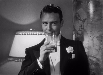 Movie still from “Holiday” (1938), directed by George Cukor – A man in a tuxedo holding a glass of water; Close Up shot, Low angle