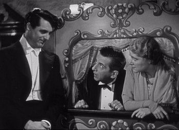 Movie still from “Holiday” (1938), directed by George Cukor – A black - and - white photo of a man and two women; Medium shot, High angle