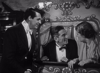 Movie still from “Holiday” (1938), directed by George Cukor – A group of men sitting on top of a wooden bench; Medium shot, High angle