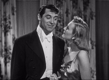 Movie still from “Holiday” (1938), directed by George Cukor – A man and a woman standing next to each other; Medium shot, Low angle