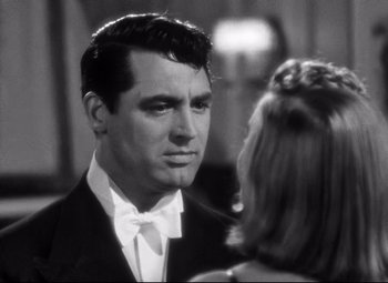 Movie still from “Holiday” (1938), directed by George Cukor – A man in a suit and bow tie talking to a woman; Close Up shot, Over the shoulder angle