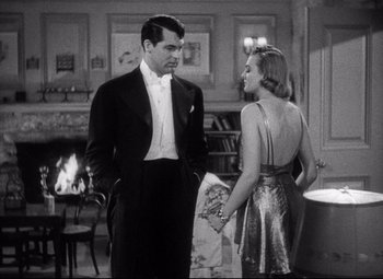 Movie still from “Holiday” (1938), directed by George Cukor – A black and white photo of a man and a woman; Medium shot, Over the shoulder angle