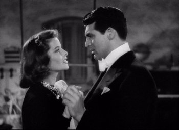 Movie still from “Holiday” (1938), directed by George Cukor – A man and a woman in formal wear holding hands; Medium shot, Low angle