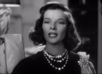Movie still from “Holiday” (1938), directed by George Cukor – A black and white photo of a woman wearing pearls; Close Up shot, Low angle