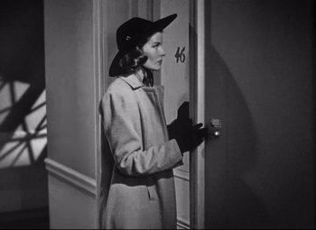 Movie still from “Holiday” (1938), directed by George Cukor – A black and white photo of a woman opening a door; Medium shot, High angle