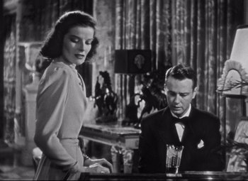 Movie still from “Holiday” (1938), directed by George Cukor – A man and a woman are sitting at a bar; Medium shot, Low angle
