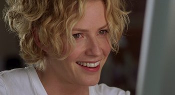Movie still from “Hollow Man” (2000), directed by Paul Verhoeven – A person with curly hair smiling; Close Up shot, Over the shoulder angle