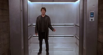 Movie still from “Hollow Man” (2000), directed by Paul Verhoeven – A man standing in an elevator with his arms outstreched; Wide shot, Low angle