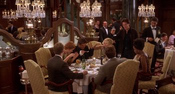 Movie still from “Hollow Man” (2000), directed by Paul Verhoeven – A group of people sitting around a table with wine glasses; Wide shot, Over the shoulder angle