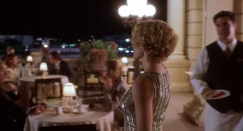 Movie still from “Hollow Man” (2000), directed by Paul Verhoeven – A woman standing in front of a table with a plate of food on top of it; Medium shot, Over the shoulder angle