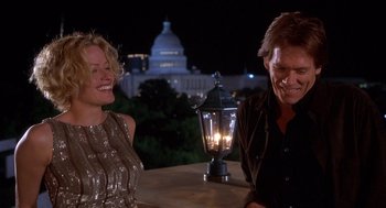 Movie still from “Hollow Man” (2000), directed by Paul Verhoeven – A man and a woman sitting at an outdoor table; Medium shot, Low angle