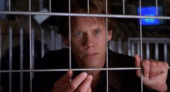 Movie still from “Hollow Man” (2000), directed by Paul Verhoeven – A man with blue eyes behind a metal fence; Close Up shot, Low angle