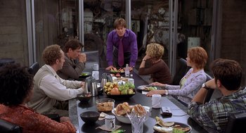 Movie still from “Hollow Man” (2000), directed by Paul Verhoeven – A group of people sitting around a table with food; Medium shot, Over the shoulder angle