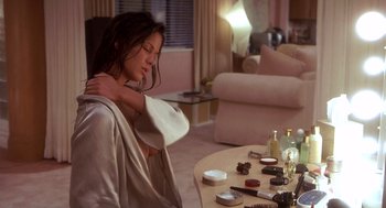Movie still from “Hollow Man” (2000), directed by Paul Verhoeven – A woman sitting in a living room holding a towel over her shoulder; Medium shot, High angle