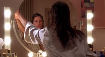 Movie still from “Hollow Man” (2000), directed by Paul Verhoeven – A woman is looking in the mirror in front of a mirror; Close Up shot, Over the shoulder angle