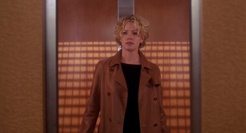 Movie still from “Hollow Man” (2000), directed by Paul Verhoeven – A woman with blonde hair wearing a brown jacket; Medium shot, Low angle