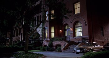 Movie still from “Hollow Man” (2000), directed by Paul Verhoeven – A car parked in front of a building at night; Extreme Wide shot, High angle