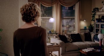 Movie still from “Hollow Man” (2000), directed by Paul Verhoeven – A woman standing in front of a window in a living room; Wide shot, Over the shoulder angle
