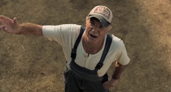 Movie still from “Holy Lands” (2017), directed by Amanda Sthers – An older man wearing a hat and overalls; Close Up shot, Low angle