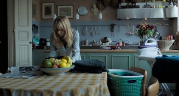Movie still from “Holy Lands” (2017), directed by Amanda Sthers – A woman in a kitchen preparing a bowl of fruit; Medium shot, High angle