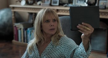 Movie still from “Holy Lands” (2017), directed by Amanda Sthers – A woman sitting in a chair holding a book; Close Up shot, High angle